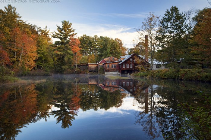 Autumn landscape with old mill reflected in a calm lake