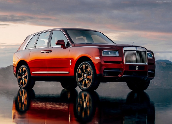 Red Rolls-Royce Cullinan SUV on reflective surface