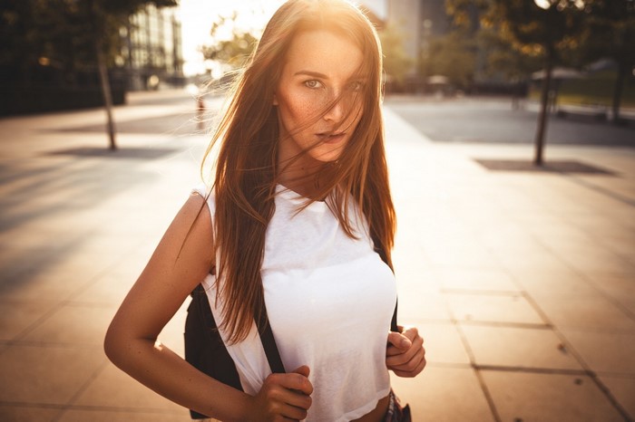Woman with freckles and long hair in sunlight