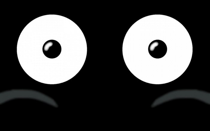 Two large white circles with black pupils on a black background