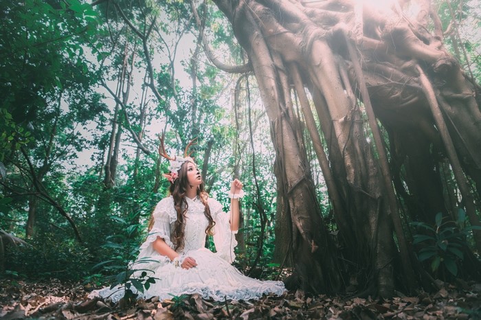 Woman with deer antlers in a forest