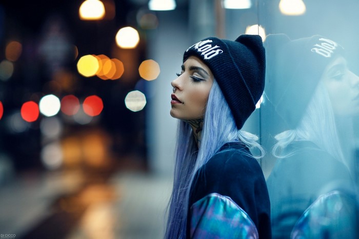 Woman with dyed hair and tattoos wearing a beanie