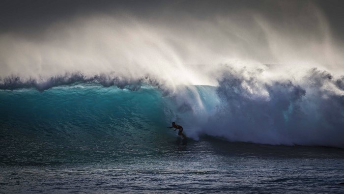 Surfer riding a massive wave in the ocean
