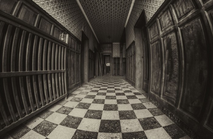 Monochrome hallway with checkered floor and wooden paneling