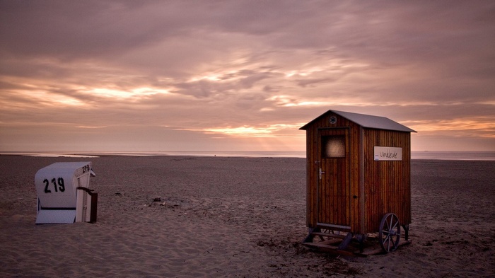 Beach huts and chairs at sunset