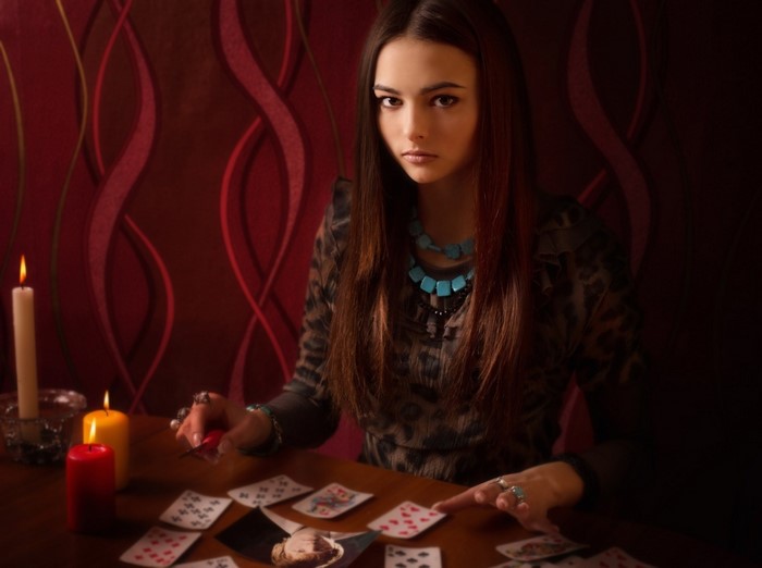 Woman reading playing cards by candlelight