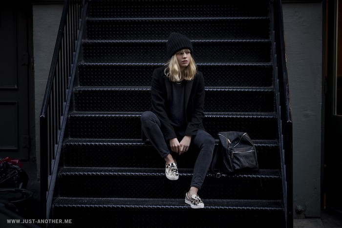 Lisa Dengler sitting on dark stairs with backpack