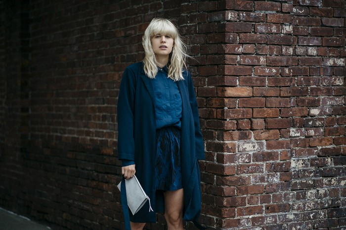 Model Lisa Dengler in blue outfit against brick wall