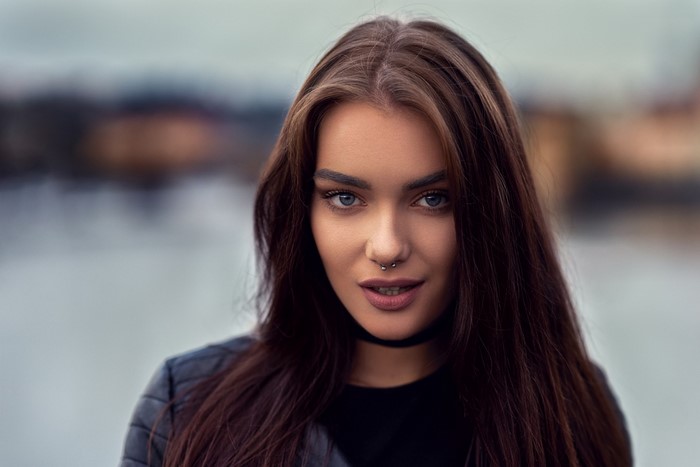 Woman with long brown hair and septum piercing
