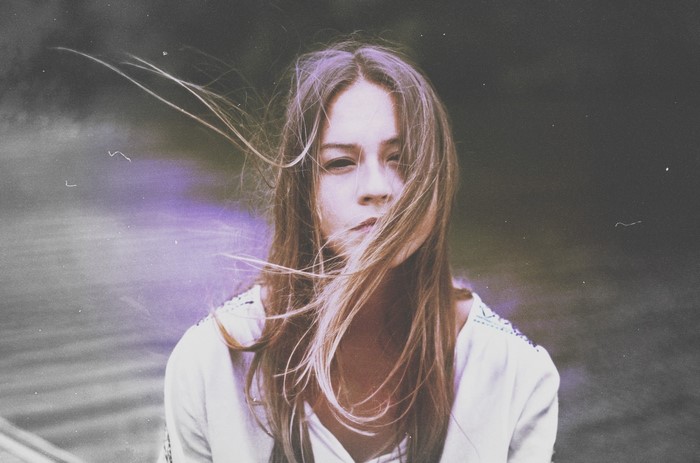 Woman with windblown hair in a white top