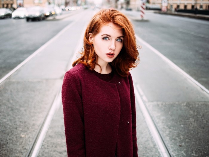 Woman with red hair in a burgundy coat