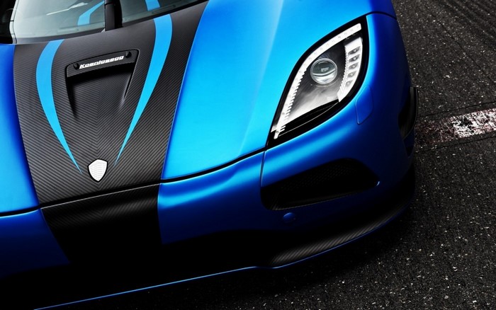Blue Koenigsegg sports car with carbon fiber accents