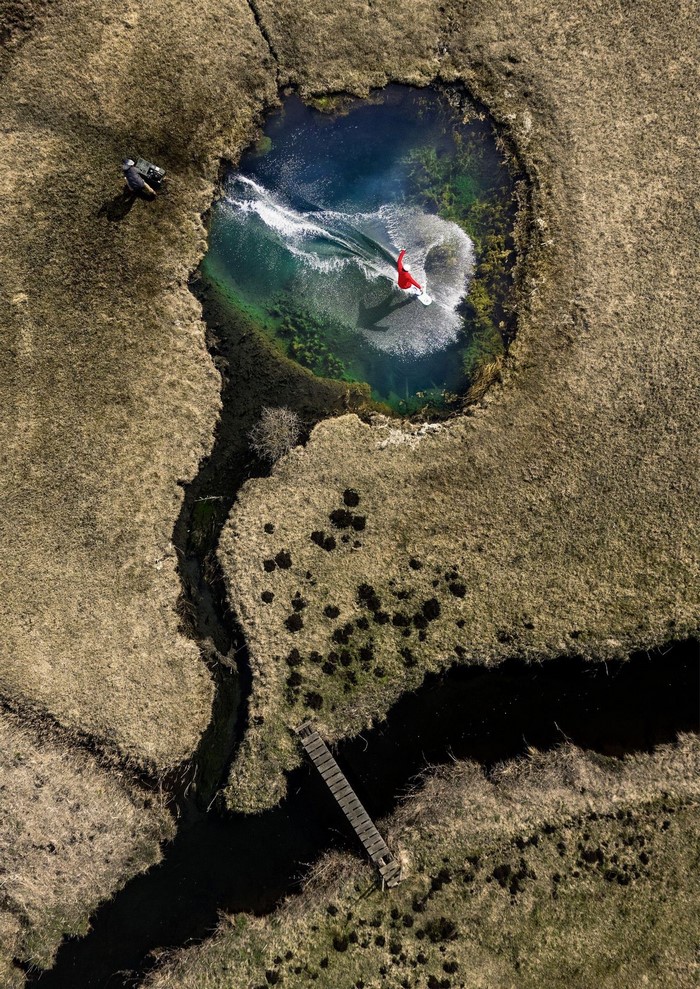 Man wakeboarding in a small pond with a photographer