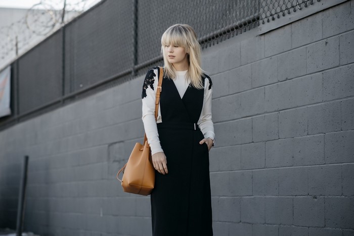 Woman in black dress and white top with lace
