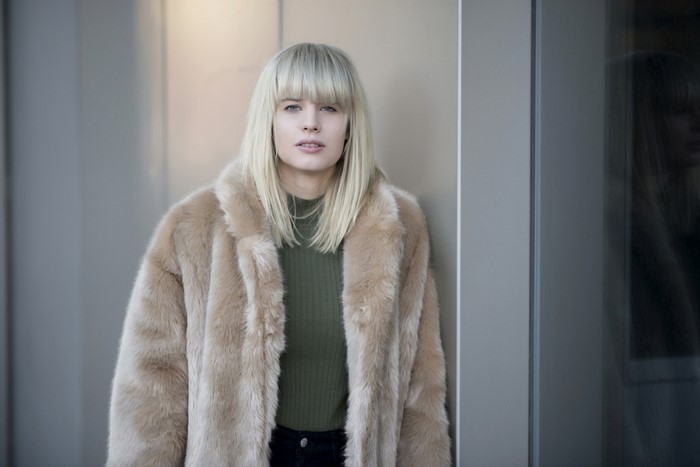 Woman in fur coat and green sweater