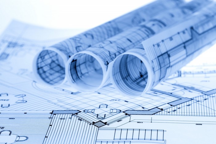 Rolled blueprints and architectural drawings on a table