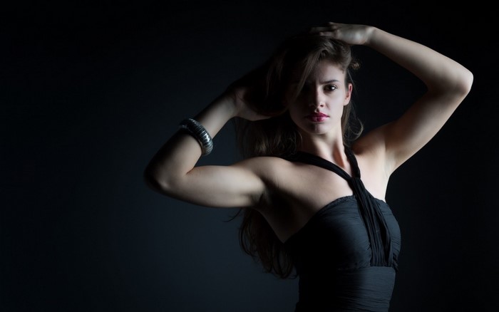 Woman with hands on head in black dress