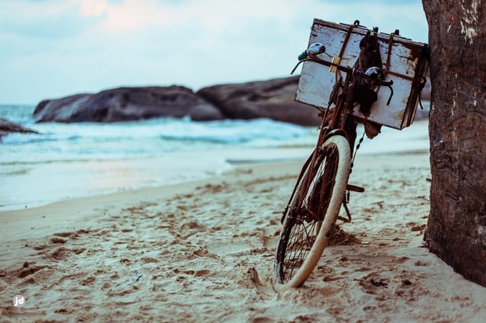 Old bicycle with a wooden box on a sandy beach
