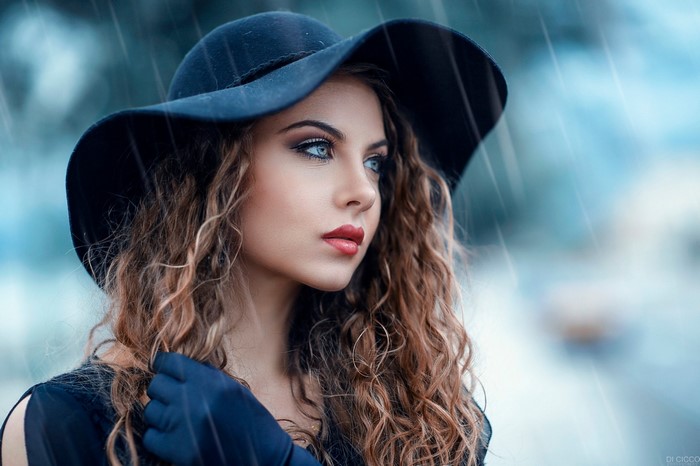 Woman with Curly Hair in Black Hat in Rain