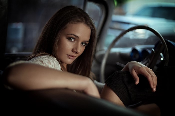 Woman in car interior looking at viewer