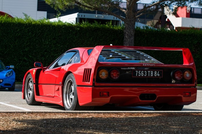 Red Ferrari F40 parked next to a blue Lotus