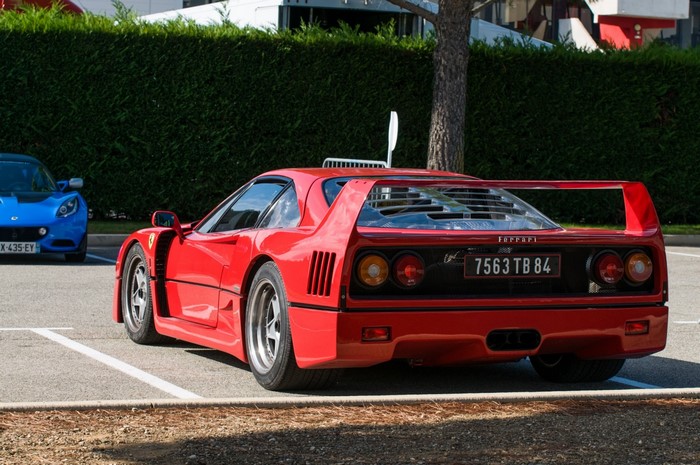 Red Ferrari F40 parked next to a blue Lotus