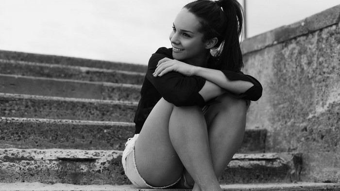 Smiling Woman Sitting on Outdoor Steps in Monochrome