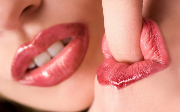 Close-Up of Glossy Red Lips with Finger