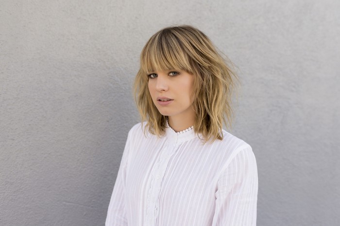 Woman with blonde hair wearing a white shirt