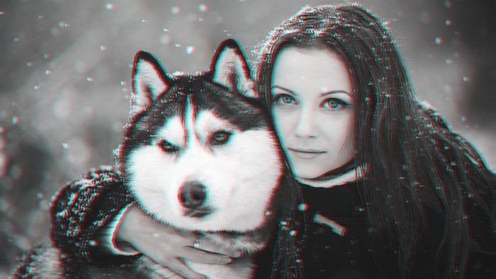 Woman hugging a Siberian Husky in the snow