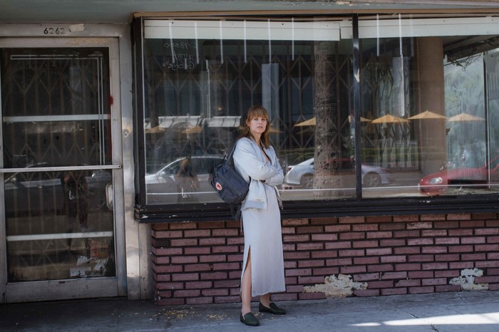 Woman with backpack standing in front of a storefront