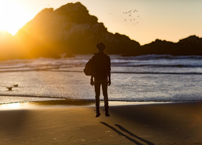 Person jumping on a beach at sunset