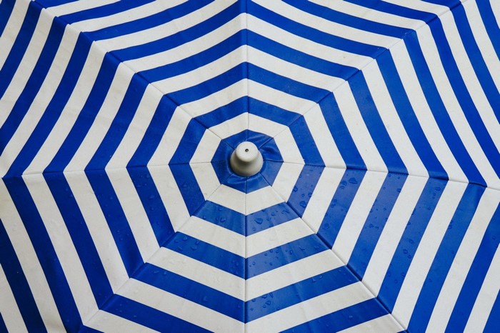 Blue and white striped umbrella with water drops