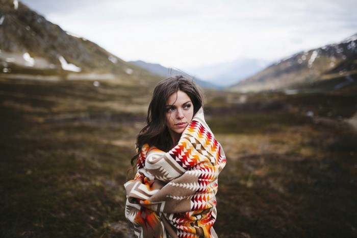 Woman wrapped in blanket in mountains