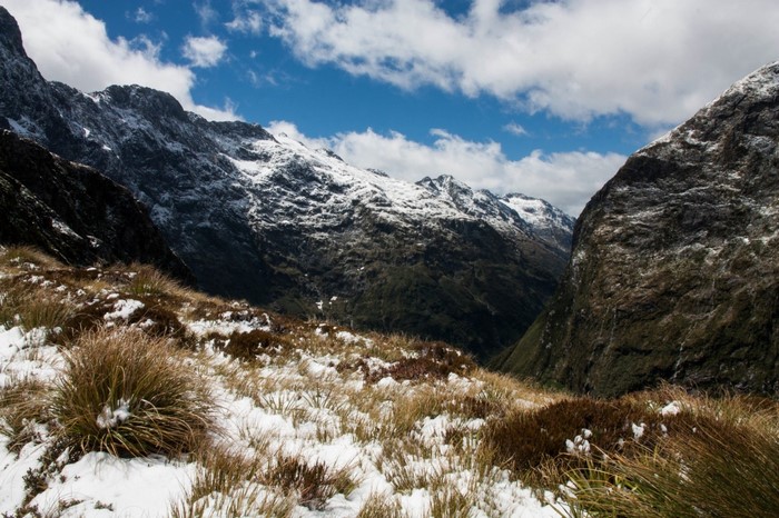 Snow-covered mountains and valley with dry grass