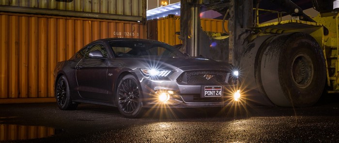 Ford Mustang GT parked at night with shipping containers