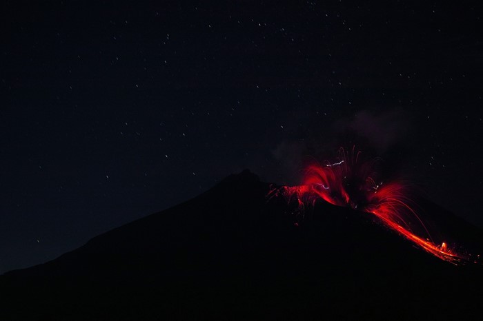Volcano eruption at night with stars