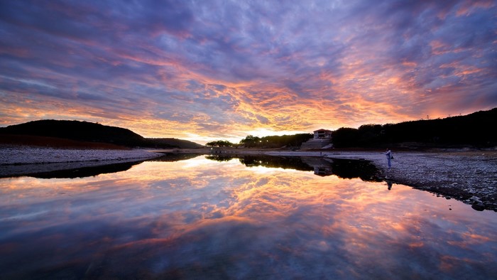 Sunset over a calm lake with colorful clouds and reflections