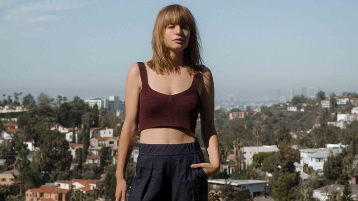 Woman with bangs in a burgundy crop top and navy pants