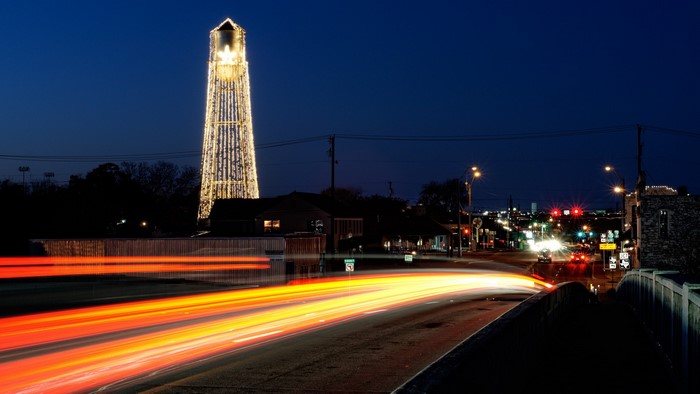 Round Rock water tower lit up at night with light trails