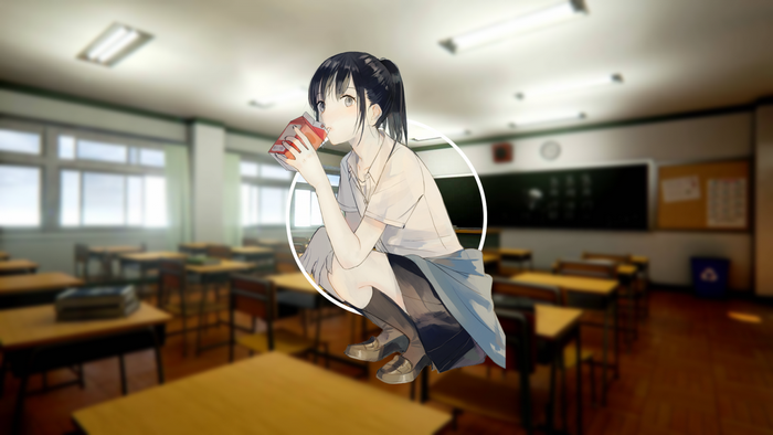Schoolgirl drinking from a juice box in a classroom