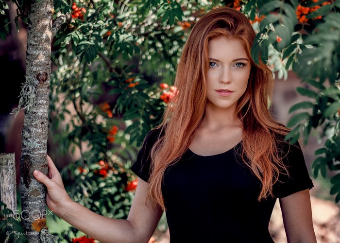 Redheaded Woman in Black Among Greenery