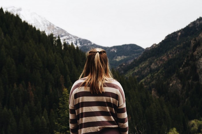 Woman in striped sweater looking at mountains
