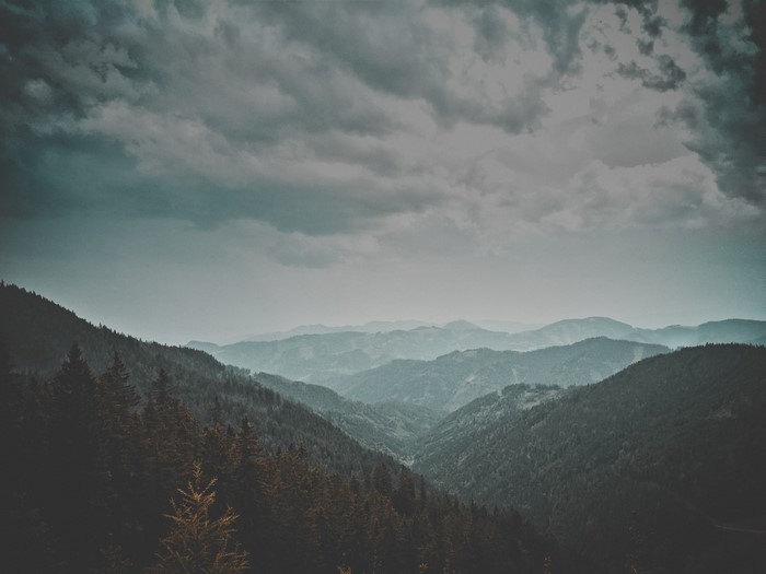 Misty mountain range with dark clouds