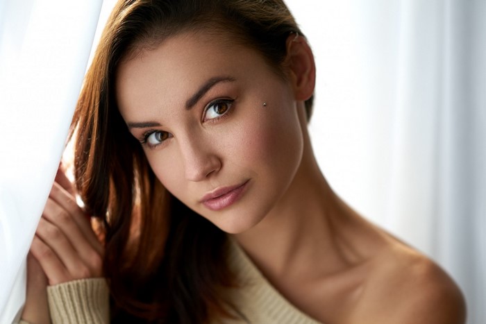 Woman with brown hair and piercing posing