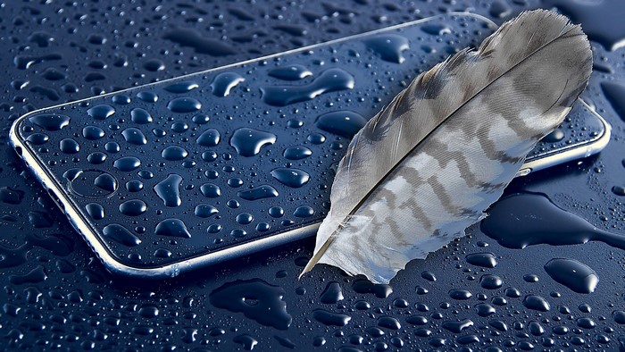 Smartphone with water drops and feather