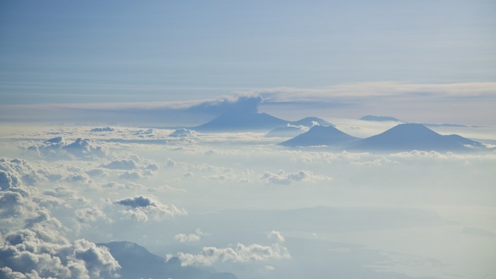 Mountains above clouds in the sky