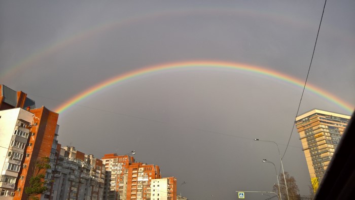 Double rainbow over city buildings