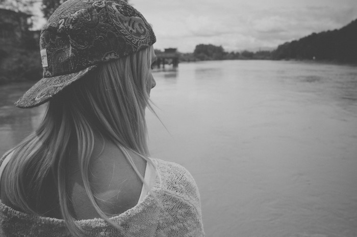 Woman wearing a cap looking at a river