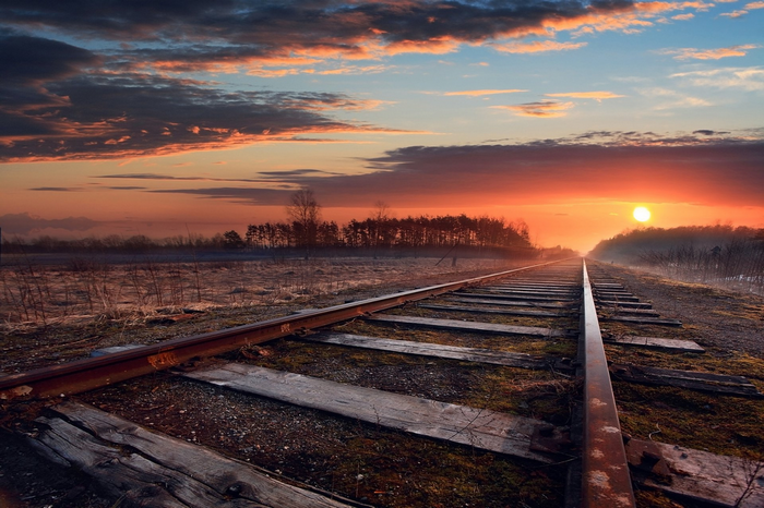 Railway tracks at sunset with colorful clouds